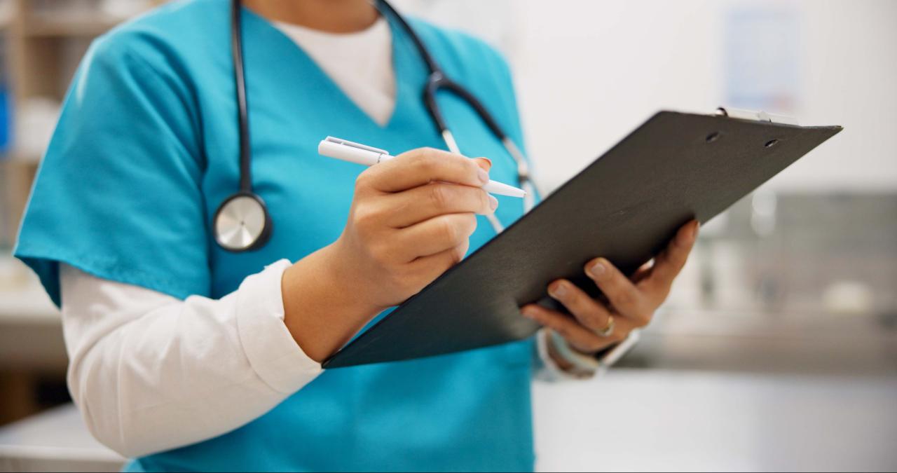Nurse writing on a medical chart
