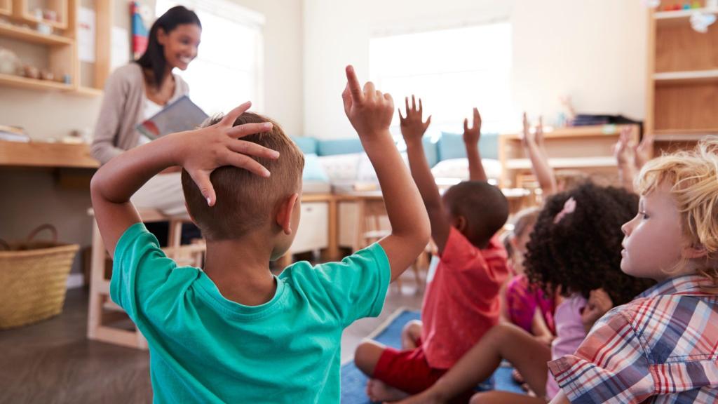 Elementary students raising their hands