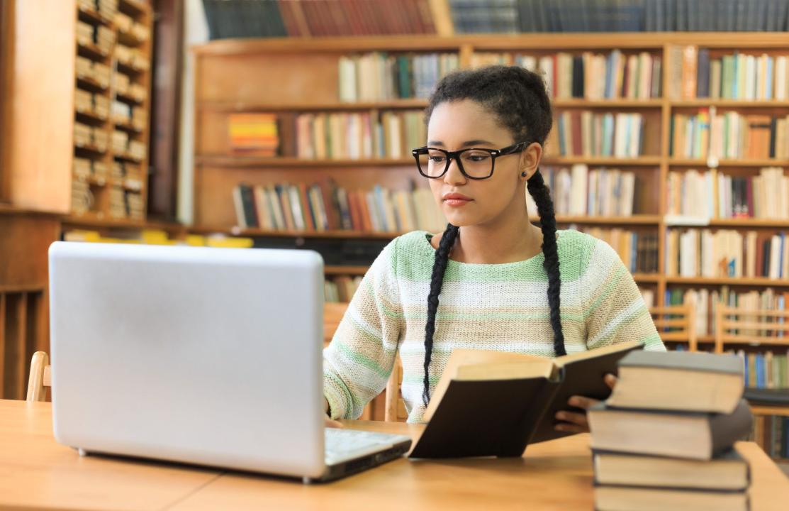Concentrated young woman using a laptop in the library