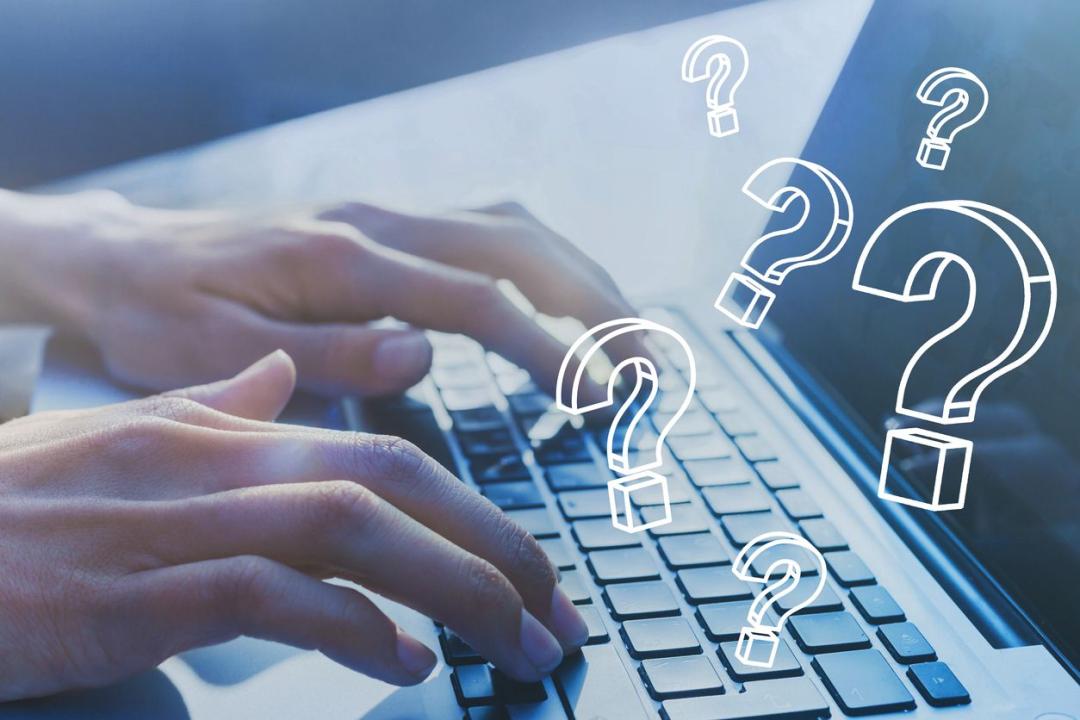 person using a laptop with question marks