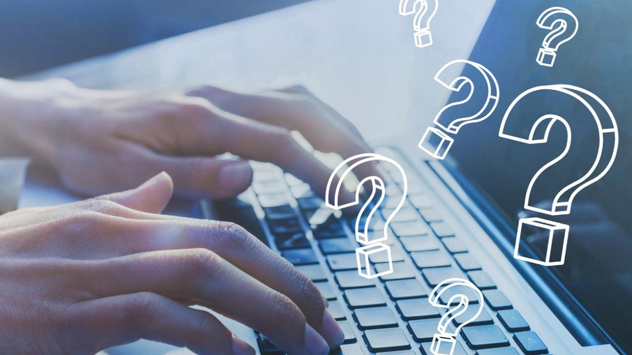 person using a laptop with question marks
