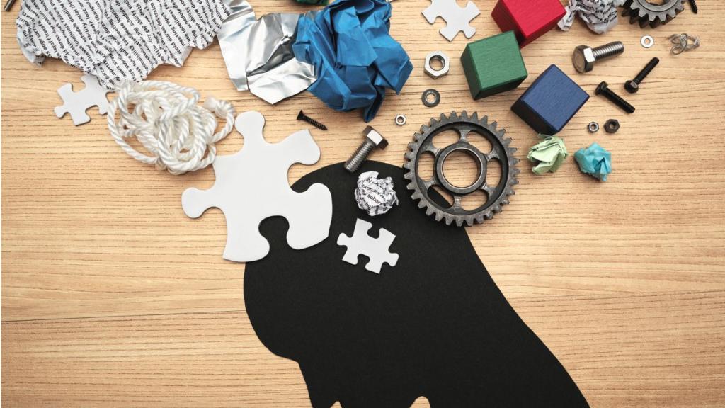 Various parts and head silhouette on wood background.