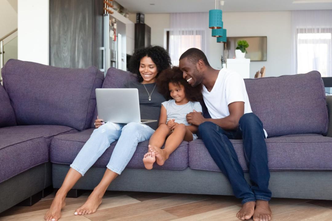 Happy family with daughter using laptop at home
