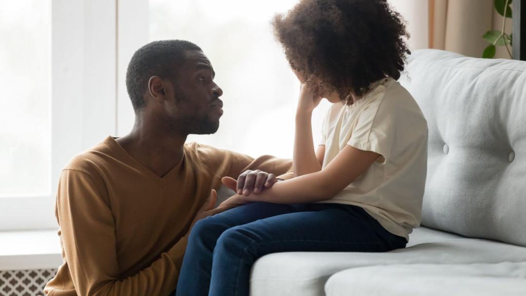 Loving dad comforting crying daughter showing empathy
