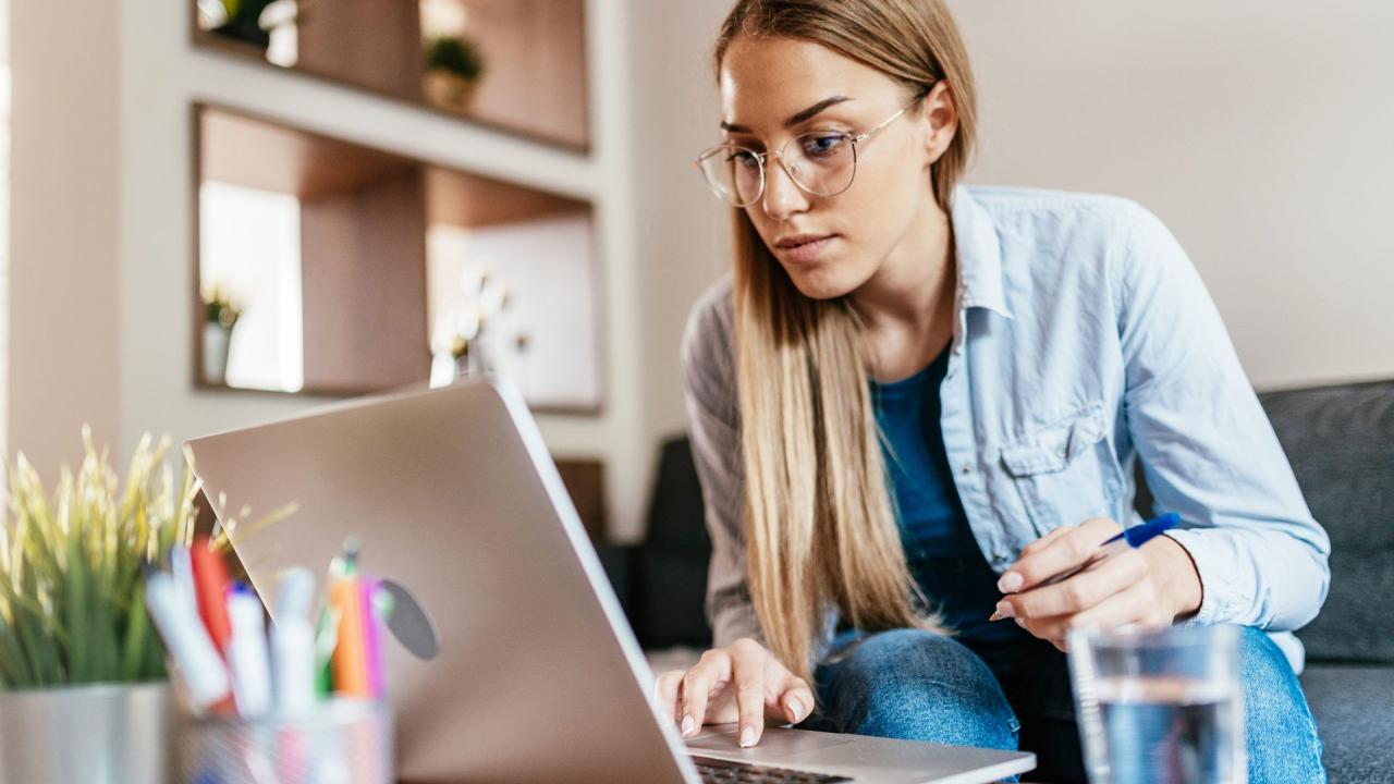 Serious woman working on laptop at home during covid-19 quarantine