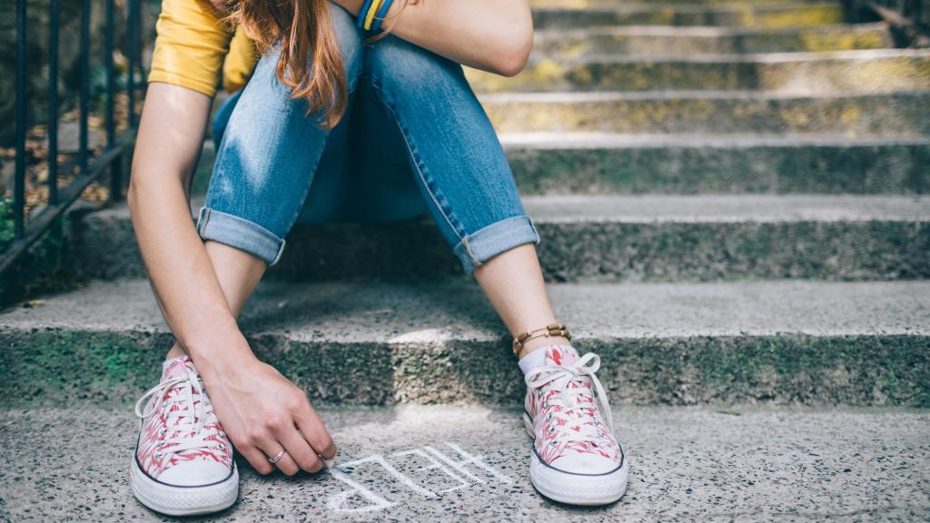 Unahppy girl writes help on the ground