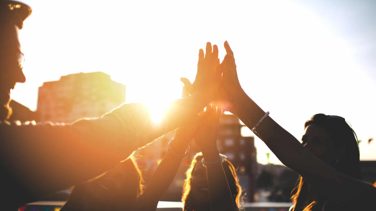 Happy friends at the rooftop doing high five
