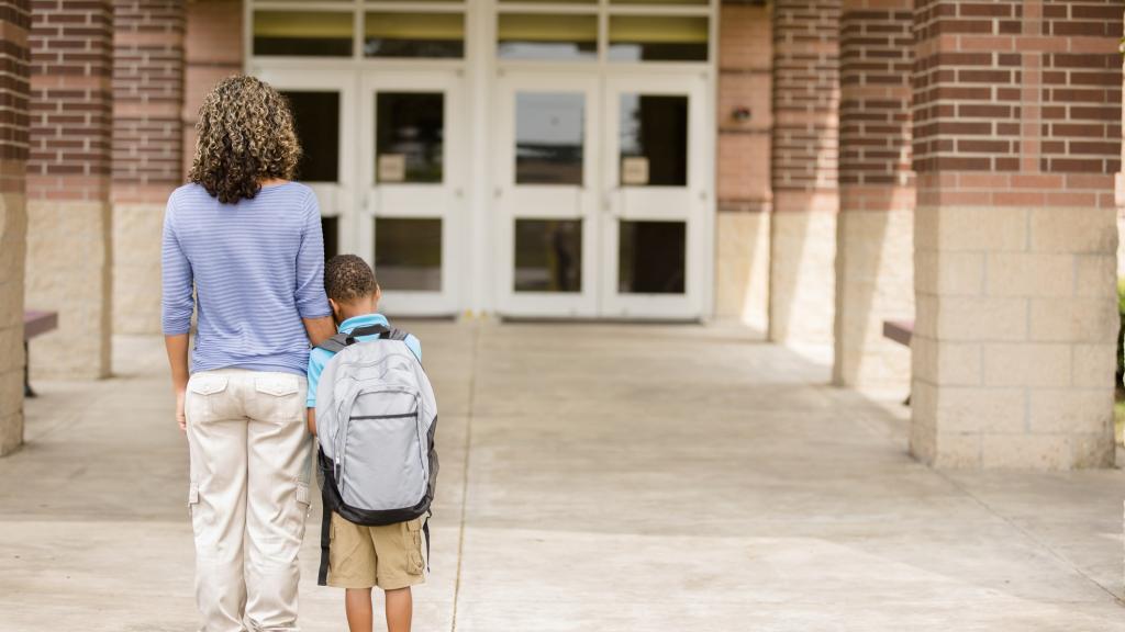 Nervous boy. First day of school.  Holds on to mom.