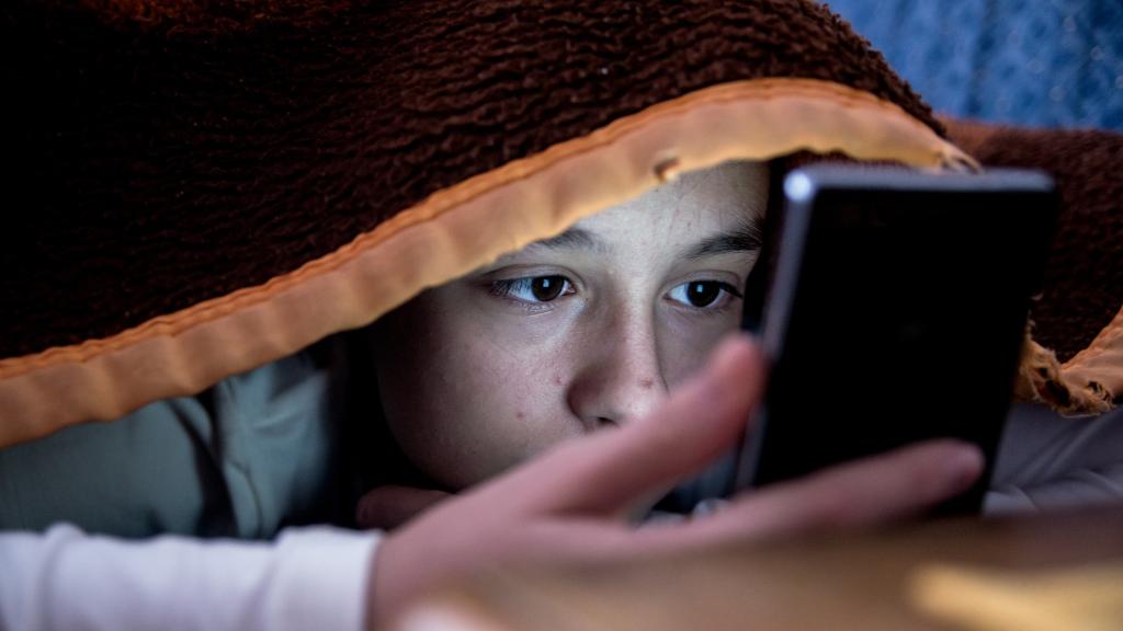 girl in bed texting on smartphone