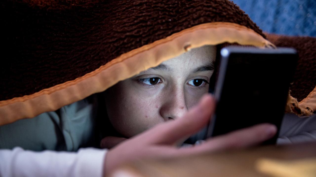 girl in bed texting on smartphone