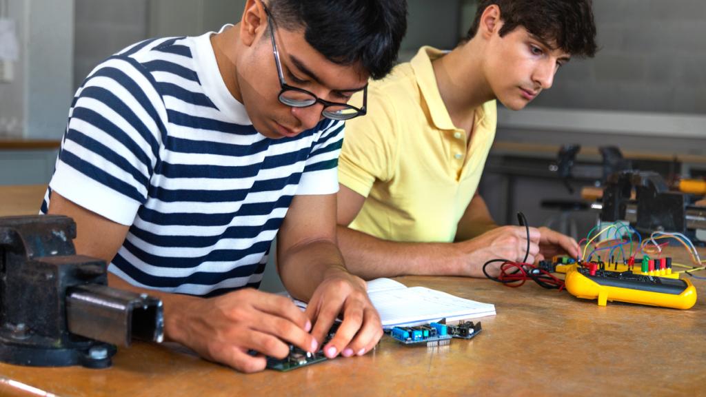 Male multiracial teen high school students working together on a project in electronics class. Education. Cooperation