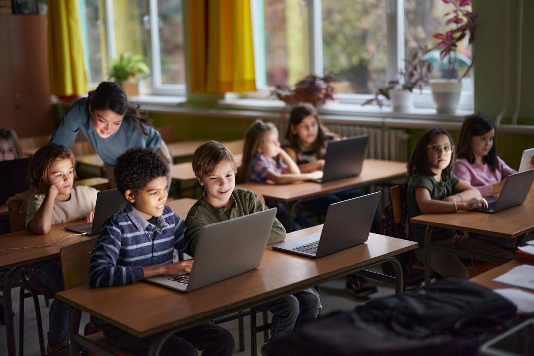 Elementary students e-learning over laptops in the classroom.