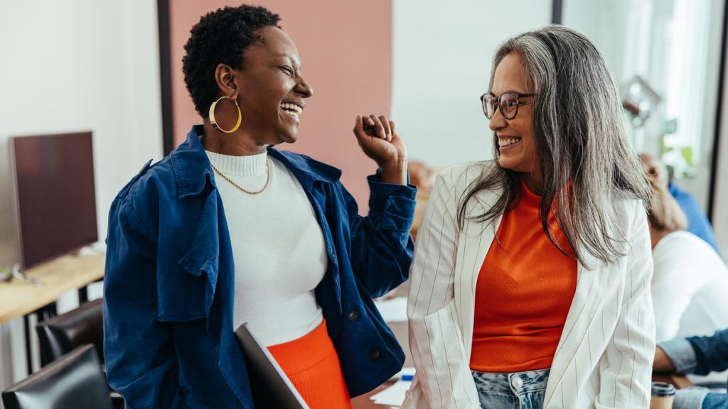 Creative colleagues laughing in a vibrant and colorful workplace