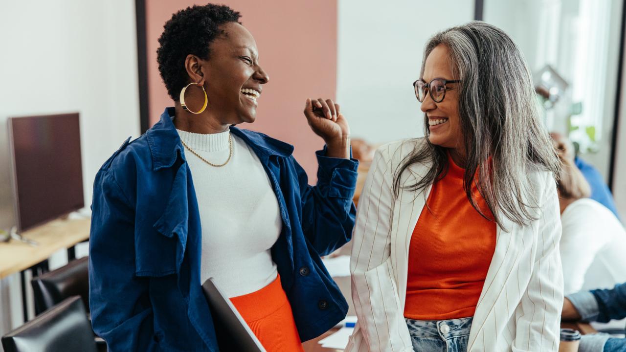 Creative colleagues laughing in a vibrant and colorful workplace