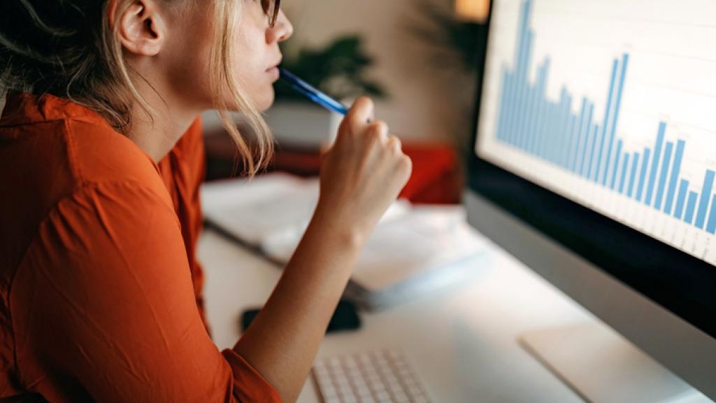 Woman looking at a computer screen displaying a bar graph