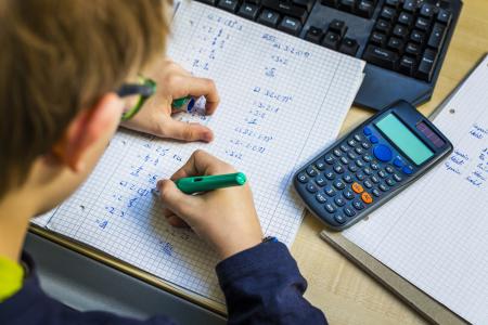 Teen writing in pen on graph paper