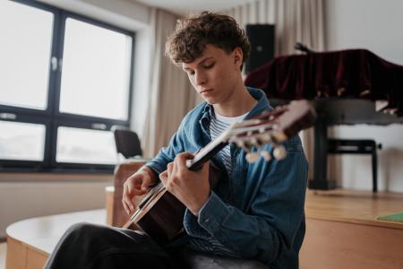 Teenage boy playing guitar