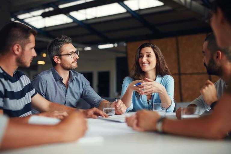 photo of a group of professionals sitting around a table talking
