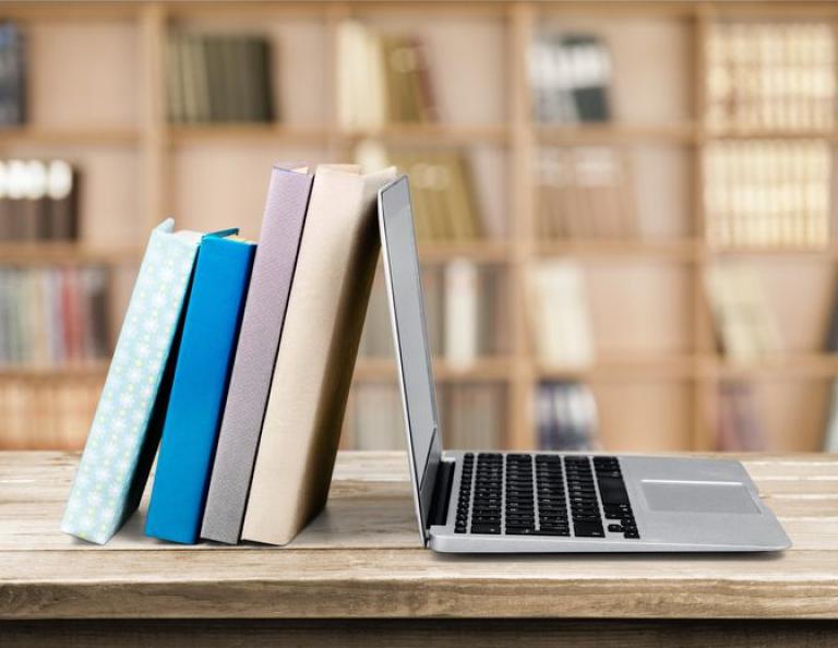books leaning against a laptop