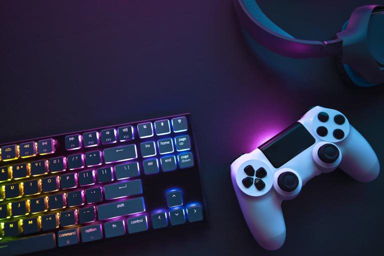 Top down view of colorful illuminated gaming accessories laying on table.