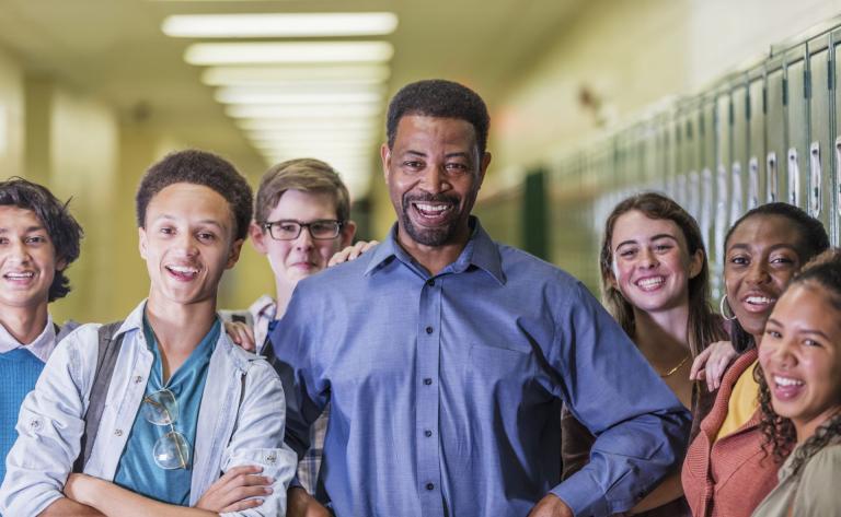 Principal and high school students hanging out in hallway