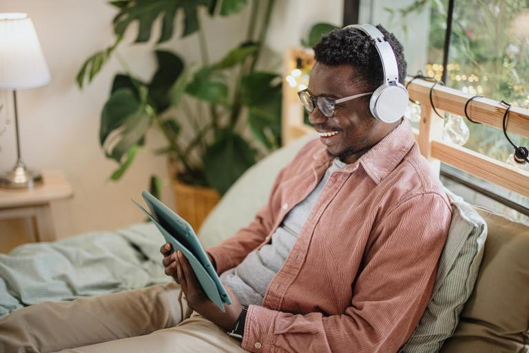 Young man watching funny TV series and movies via streaming service at home