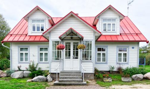 A large home with white siding and a red roof.