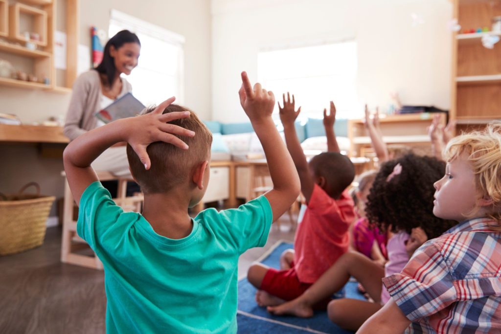 Elementary students raising their hands