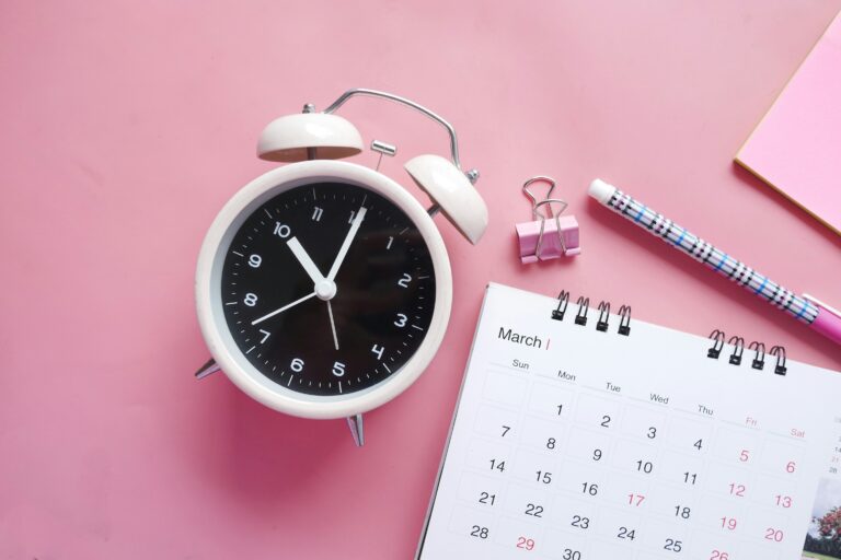 image of an analog block on a pink background with a March calendar